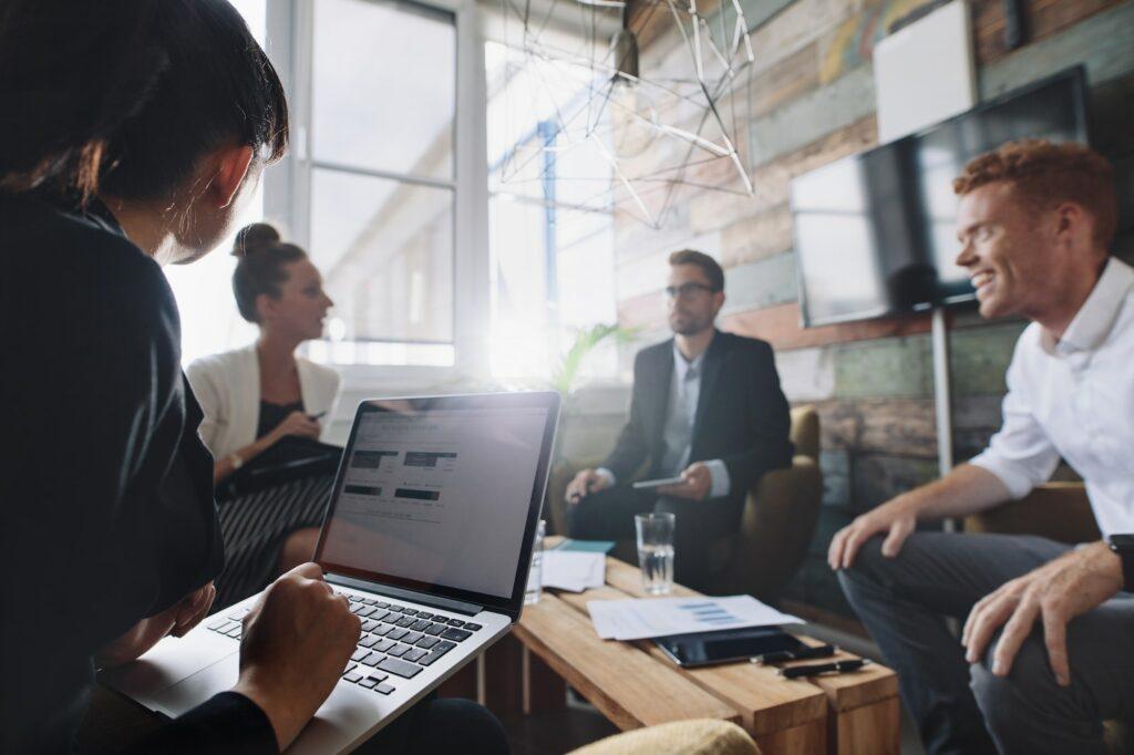 Businesswoman working on laptop in meeting Kontaktieren sensibilisieren